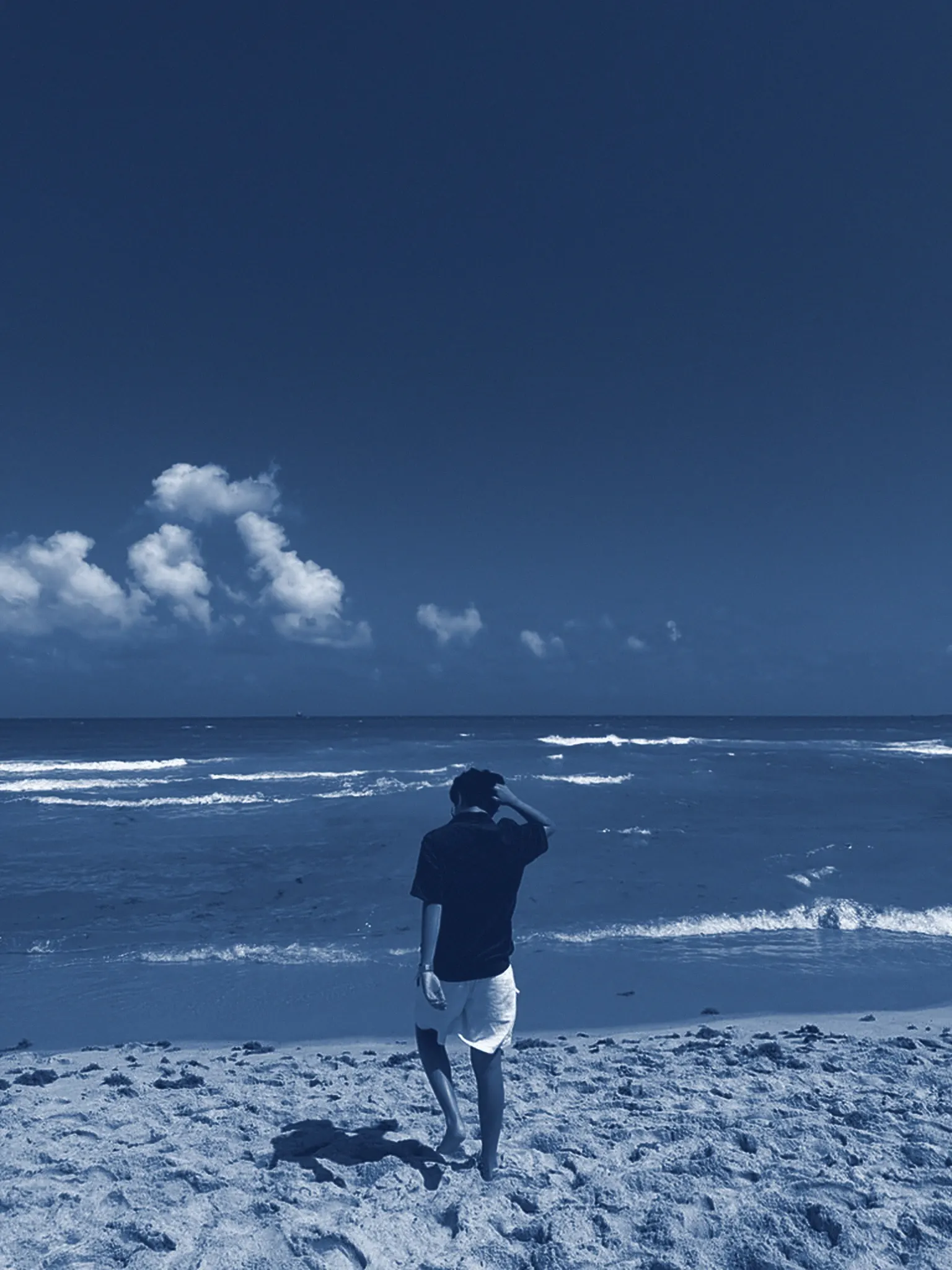 Guillermo Hernández, Founder / Creative of HerZú Studio, walking on the beach toward the sea.
