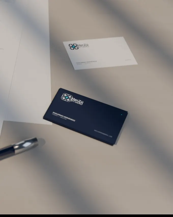 Render of HerZú Studio business cards on a stone table, navy card with the lockup in focus.